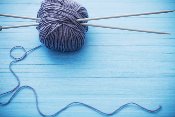 Knitting and knitting needles on a wooden surface - Fotoğraf, Görsel