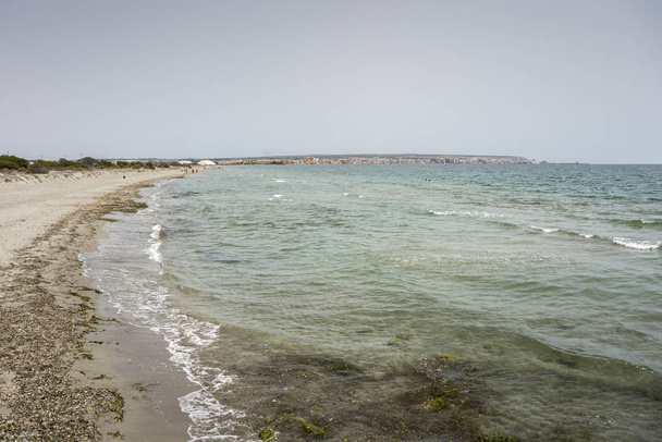 Vista da Praia do Tamarit, em Santa Pola, Alicante, Espanha, junto ao Mar Mediterrâneo. No fundo pode ser visto de cidade e montanhas de sal
 - Foto, Imagem
