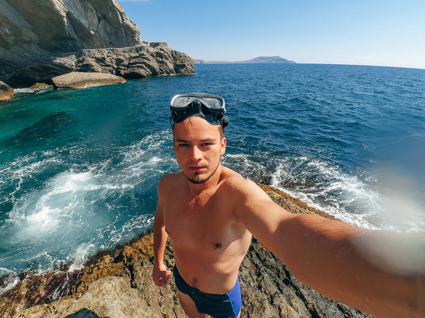水泳パンツ姿で海のショアでマスク立ちで selfie スポーツ男性ダイバー - 写真・画像