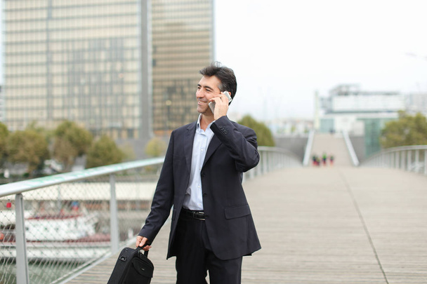Homme d'affaires européen marchant et parlant par téléphone
. - Photo, image