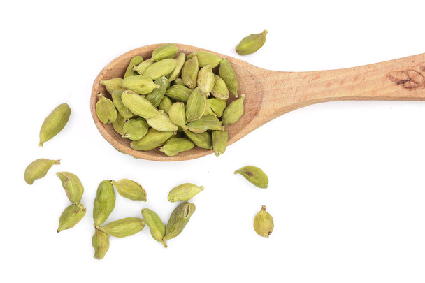Green cardamom seeds in wooden spoon isolated on white background. Top view. lay flat - Photo, Image