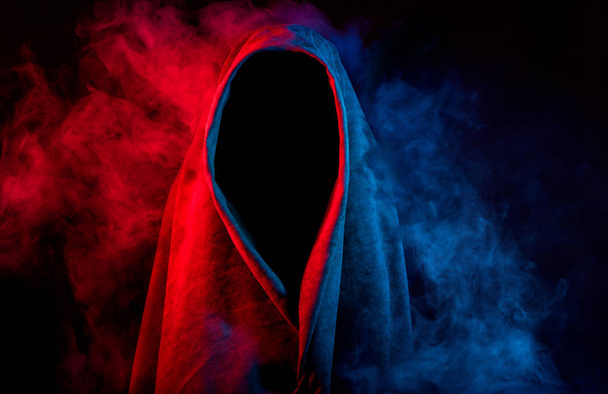 mysterious dark silhouette hidden by colorful smoke on black background - Foto, afbeelding
