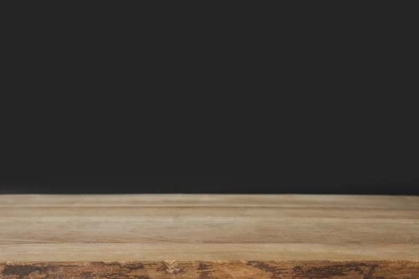 musta seinä ja puinen ruskea pöytä
 - Valokuva, kuva