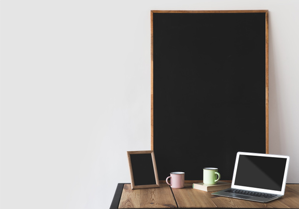 empty blackboards in frames with cups and laptop on white  - Photo, Image