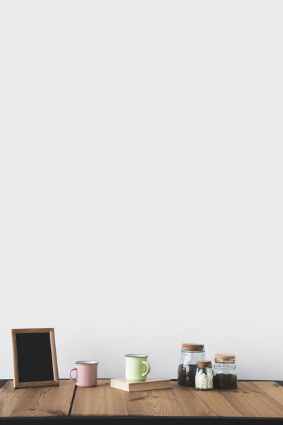 csészék és a kávé, a fából készült asztal fehér keret üres tábla  - Fotó, kép