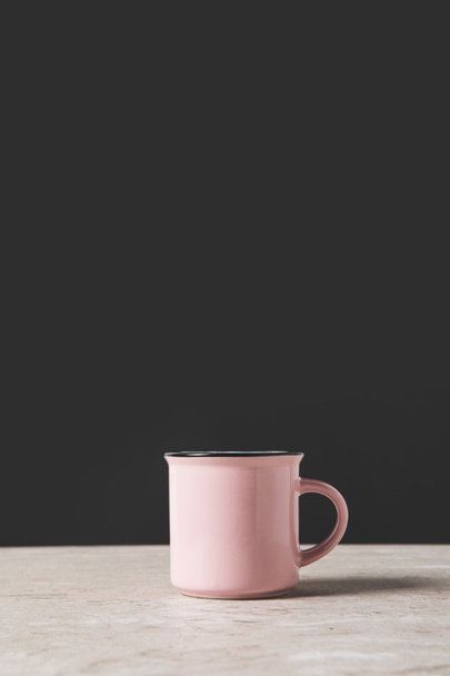une tasse rose sur table en marbre sur fond noir
 - Photo, image
