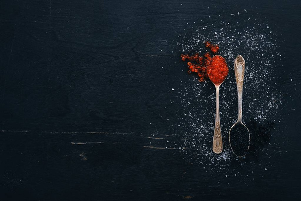 Spoon with black and red caviar on a wooden background. Top view. Free space for text. - Photo, Image