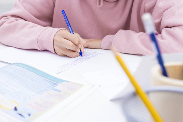 το χέρι του παιδιού μελετώντας και γράφοντας στο σχολείο γραφείο ή το σπίτι - Φωτογραφία, εικόνα