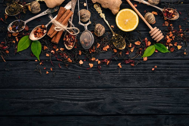 Assortment of dry teas and fragrant herbs and spices. On a wooden background. Top view. Copy space. - Zdjęcie, obraz
