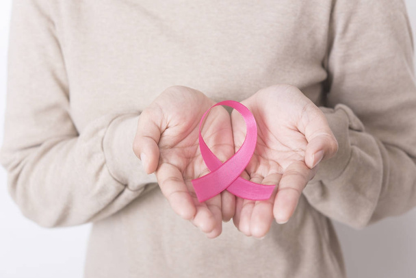 women hand holding pink ribbon breast cancer on white background. with copy space - Foto, Imagem