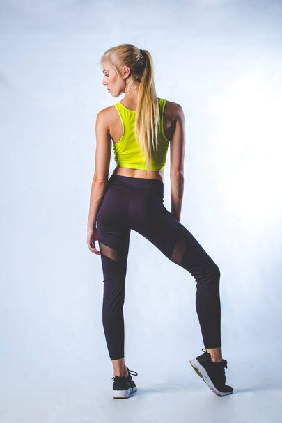Όμορφα Γυναικεία fitness μοντέλο κάνει τεντώματα και χορό σε ένα στούντιο, απομονώνονται σε λευκό φόντο - Φωτογραφία, εικόνα