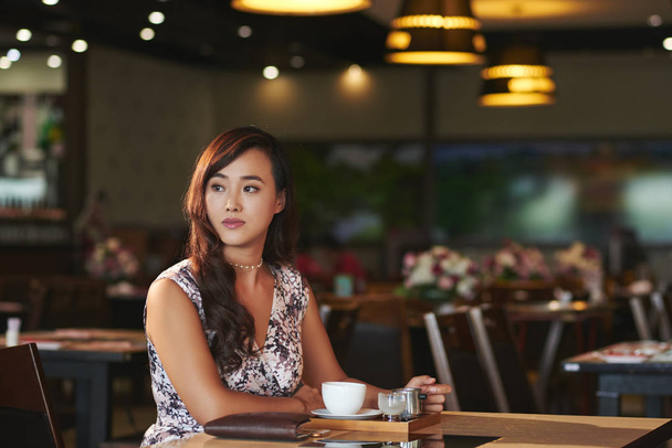 Beautiful Chinese woman enjoying cup of coffee in fancy restaurant - Foto, Bild