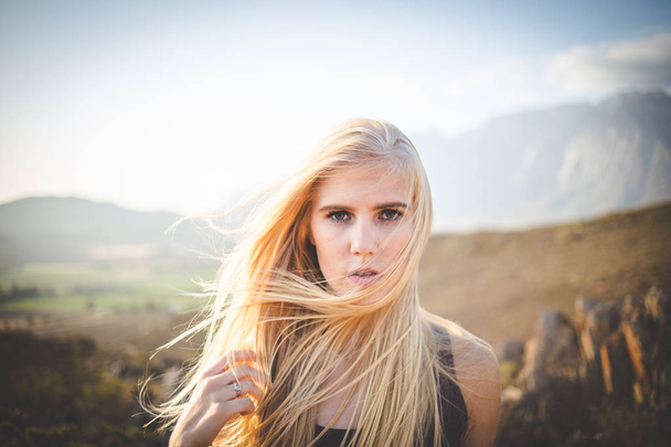 Portrait of a beautiful blonde female model in a natural setting with stunning back light - Foto, afbeelding