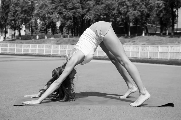yoga pose of woman training on fitness mat sunny outdoor - Fotó, kép