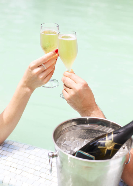 Coppia con champagne in piscina
 - Foto, immagini