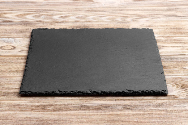 slate board on wooden background, space for writing text - Fotoğraf, Görsel