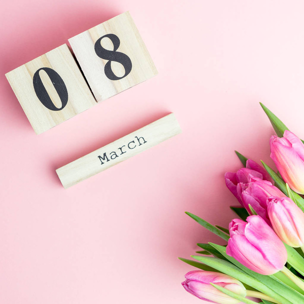 8 березня щасливі жіночий день концепції. З дерев'яних блоків календар і рожеві тюльпани на рожевий фон - Фото, зображення
