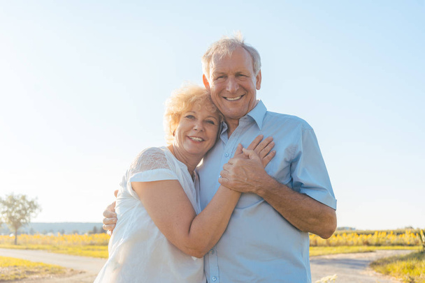 Romântico casal de idosos desfrutando de saúde e natureza em um ensolarado da
 - Foto, Imagem