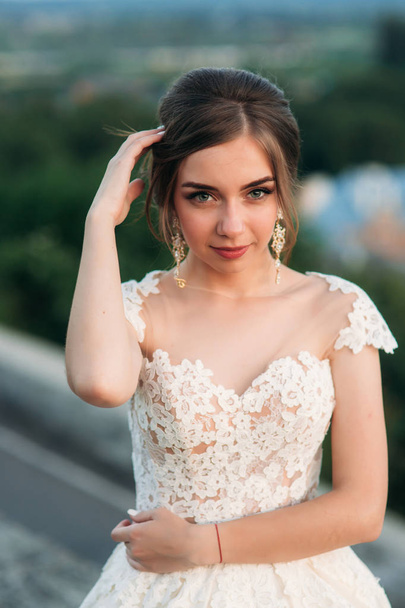 Young girl in wedding dress on city background at sunset. Summer - Fotoğraf, Görsel