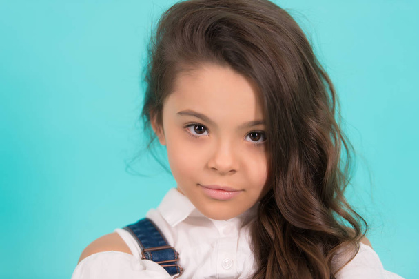 Brunette little girl pose on blue background - Valokuva, kuva