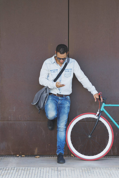 Ένας άνθρωπος επιχειρήσεων κομψό με κινητό τηλέφωνο με ρετρό ποδήλατο - Φωτογραφία, εικόνα