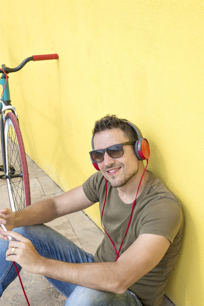 Smiling man smiling while using his headphones - Photo, image