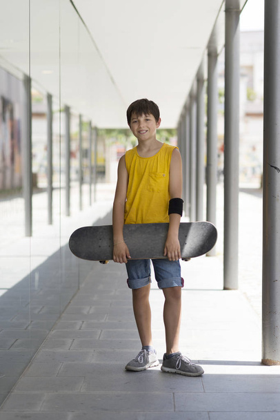Close-up van een tiener uitvoering skateboard en glimlachen - Foto, afbeelding