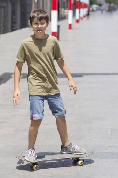 Young kid riding in the city on a skateboard. - Foto, afbeelding