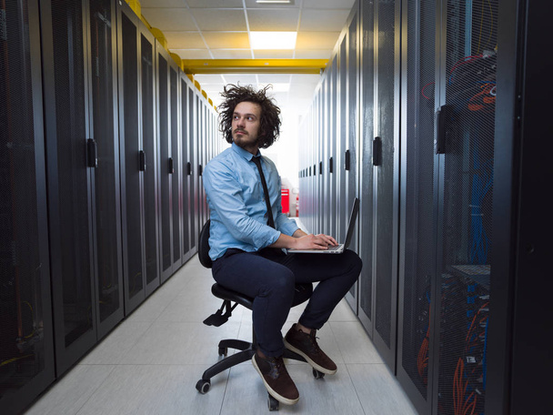 ingeniero que trabaja en una computadora portátil en la sala de servidores
 - Foto, imagen