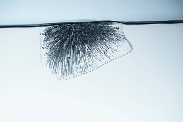 Kostka ledu tání ve vodě, izolované na bílém - Fotografie, Obrázek