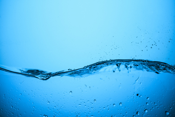 flowing water background with drops, isolated on blue - Photo, Image