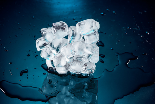 танення кубиків льоду на чорному з водою і краплями
 - Фото, зображення