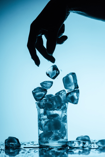 partial view of person throwing ice cubes into glass - Photo, Image