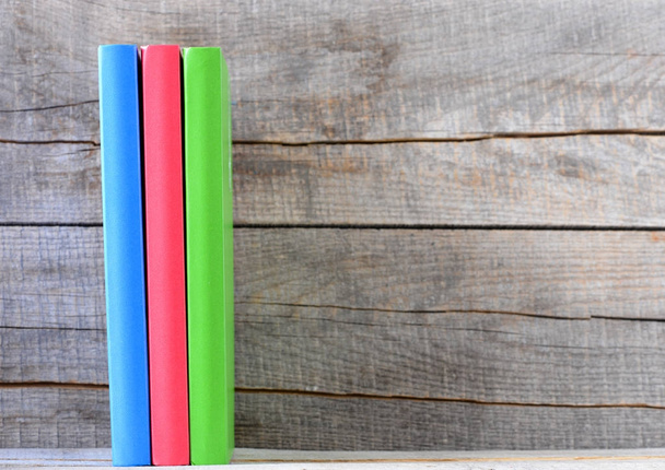Vista de cerca de tres libros sobre fondo de madera
 - Foto, imagen