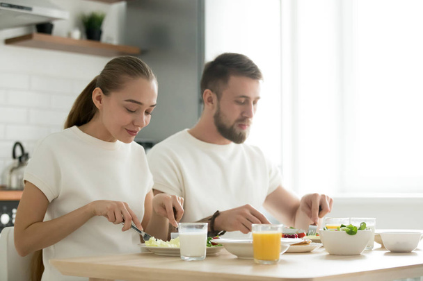 Young couple having dinner, tasting breakfast, eating together a - Фото, зображення