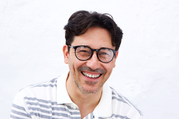 Εσωτερικη πορτρέτο του χαρούμενα ώριμος άνδρας με γυαλιά που χαμογελά σε λευκό φόντο - Φωτογραφία, εικόνα