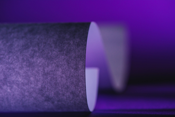 close up view of grey paper on purple surface - Foto, afbeelding