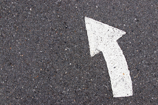 White painting in turn left direction arrow symbol on black asphalt road background - Photo, Image