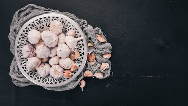 Garlic on a plate. Fresh garlic on a wooden background. Top view. Copy space. - Fotó, kép