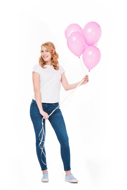 cheerful woman with pink balloons in hands looking at camera isolated on white - Foto, Imagen