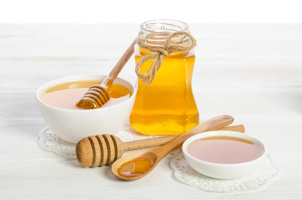 honey in a spoon, a jar and a bowl on wooden table - Photo, Image