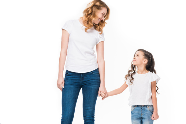 smiling mother and little daughter holding hands isolated on white - Zdjęcie, obraz
