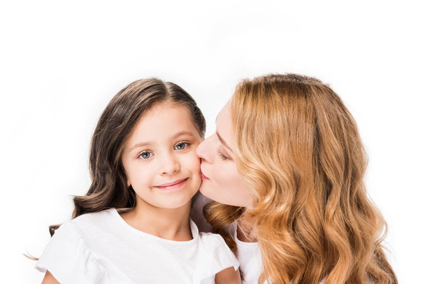 portrait of mother kissing little daughter isolated on white - Foto, Bild