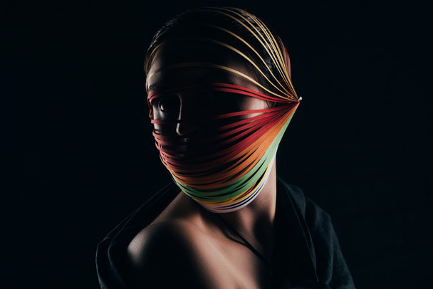 femme avec papier piquant coloré sur la tête regardant loin isolé sur noir
 - Photo, image