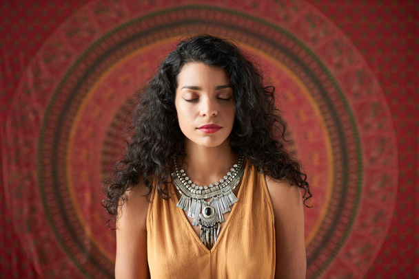 Hermosa mujer hispana meditando con los ojos cerrados
 - Foto, imagen