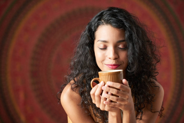 Belle jeune femme hispanique jouissant d'une odeur de café
 - Photo, image