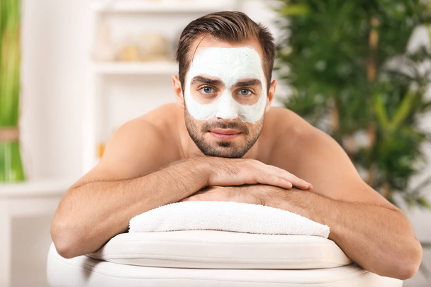 Young handsome man with cosmetic mask on face in spa salon - Fotografie, Obrázek