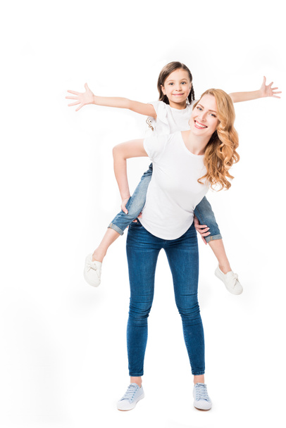 ευτυχισμένη μητέρα και κόρη μαζί piggybacking απομονωθεί σε λευκό - Φωτογραφία, εικόνα