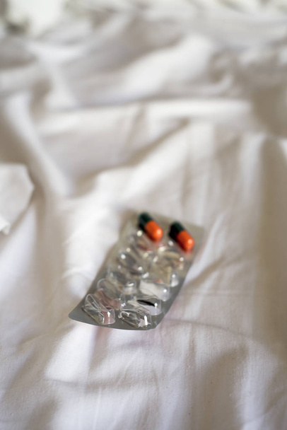 pílulas em uma embalagem blister em uma cama
 - Foto, Imagem