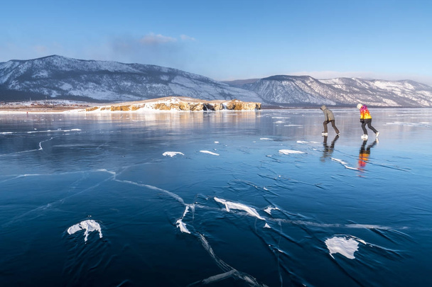 Tourists on skates go to meet the wind on Lake Baikal - Foto, imagen